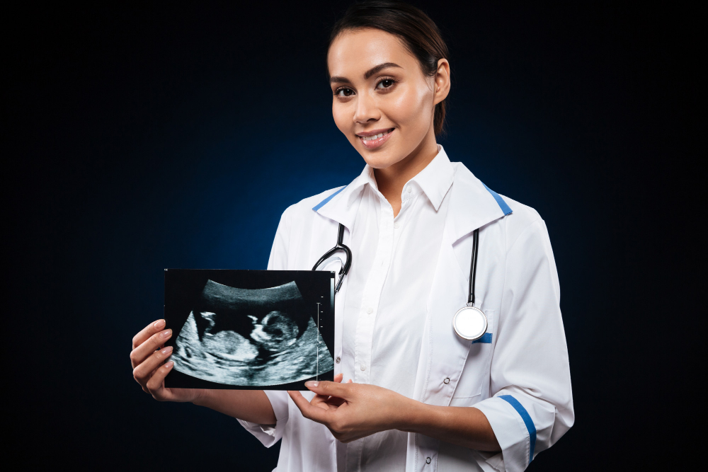 young cheerful doctor holding ultrasound scan baby